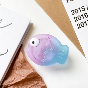 Detail of cute gradient purple fish-shaped phone grip with embossed scales and matte texture