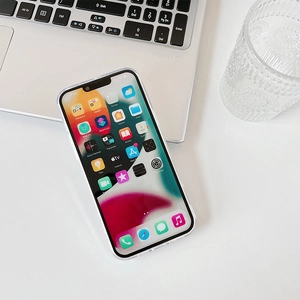 Detailed view of a clear iPhone case with electroplated hearts on a white desk