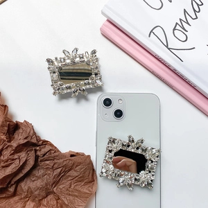 Detail of luxury rhinestone mirror phone stand on a white device with crystal accents