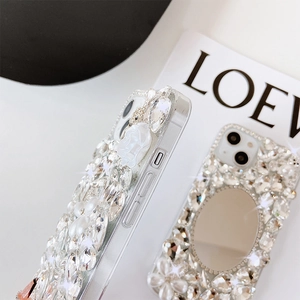Detail of luxury iPhone case featuring sparkling rhinestones, pearls, and a built-in makeup mirror