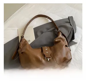 Detail of brown vintage leather hobo bag featuring silver star rivets and zipper hardware