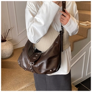 Vintage dark brown half-moon tote bag featuring metallic star studs and buckle detail