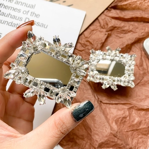 Close-up of luxury rhinestones and square mirror on a retractable phone socket grip