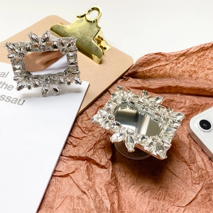 Detailed view of silver luxury rhinestone phone grips with mirror and hollow square designs