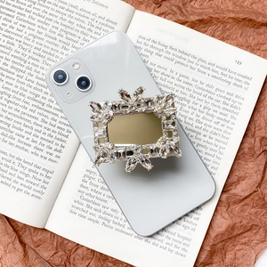Detailed view of luxury rhinestone mirror phone grip on an iPhone with crystal accents