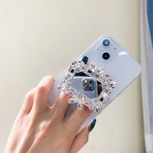 Macro detail of luxury rhinestone folding phone grip with square mirror and crystal inlay