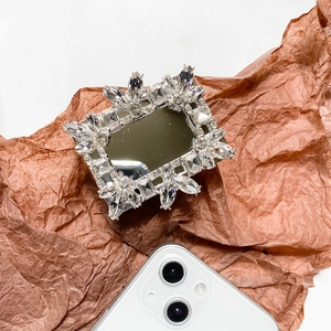 Detailed close-up of luxury rectangular phone socket with crystals on brown paper background