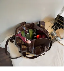 Detail view of large dark brown leather tote bag with red lining and spacious interior