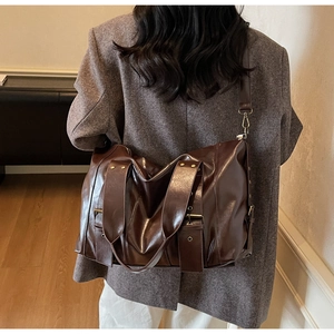 Deep brown oil wax leather tote bag with metallic rivet detail and smooth polished finish