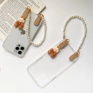 Détail de la coque iPhone transparente avec bracelet perlé et breloque de dessin animé