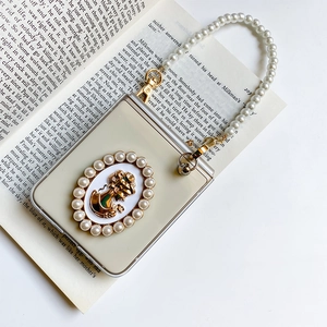 Detail of Galaxy Z Flip case featuring vintage cameo relief and pearl hand strap