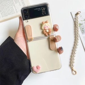 Detail of cream folding phone case with cute 3D girl and pink heart charms