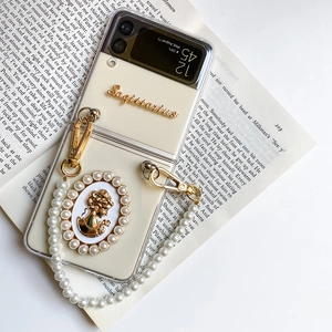 Detail of Galaxy Z Flip case with Sagittarius label, pearl chain, and vintage cameo