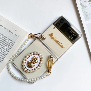 Detail of Galaxy Z Flip case with pearl bracelet and vintage Sagittarius relief