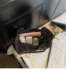 Macro view of the spacious dark brown leather tote bag interior with daily essentials