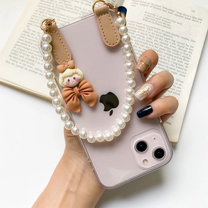 Détail de la coque iPhone rose avec bracelet en perles élégant et breloque de dessin animé