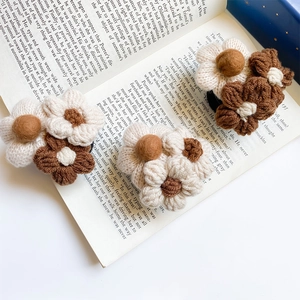 Detailed macro view of three handmade crochet flower hair clips on an open book page