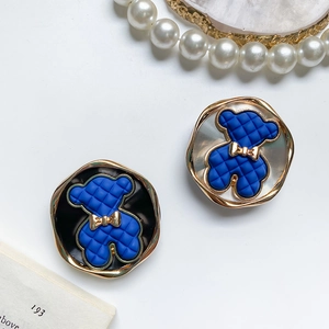 Detail of blue quilted bear phone grips with gold metallic edges on a white table