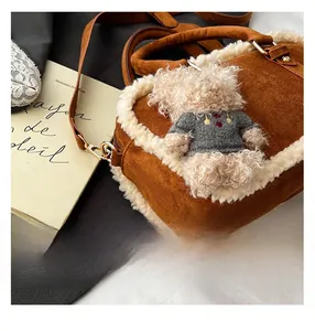 Detailed shot of brown suede crossbody bag with faux fur trim and cute teddy bear charm