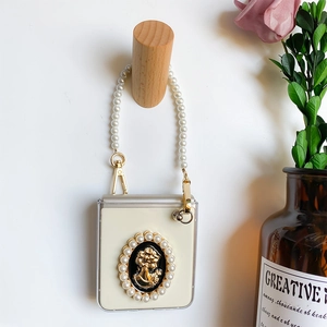 Close-up of Galaxy Z Flip case with vintage cameo relief and elegant pearl handle strap