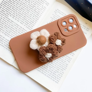 Detail of matte brown phone case with handcrafted 3D knitted flower decorations
