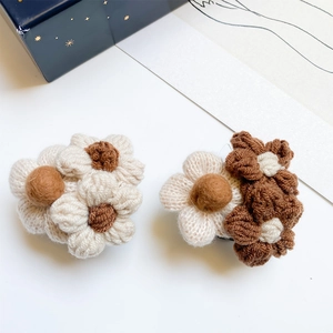 Close-up of hand-knitted plush flower phone grip with soft coffee contrast colors
