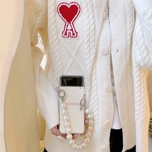 Detail of Samsung Z Flip clear case with elegant pearl crossbody chain and hand strap