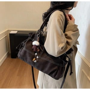 Detail der dunkelbraunen Leder-Shopper mit Kontrastnähten und seitlichem Kordelzug-Design