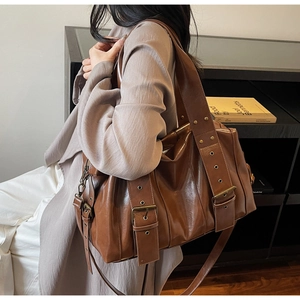 Detail view of large brown PU leather tote bag with vintage metal buckles and adjustable straps