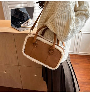 Close-up of a vintage brown suede crossbody bag with white shearling trim detail