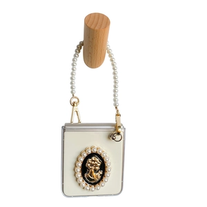Creamy white Samsung Z Flip phone case with pearl bracelet strap and retro cameo charm