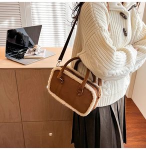 Close-up of brown suede handbag with white faux fur trim and adjustable strap