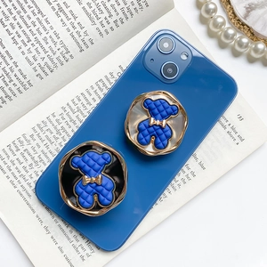 Blue plaid 3D bear cell phone grip stand with gold bow on a blue smartphone case