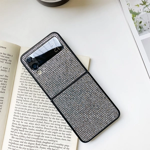 Detail of luxury glitter case for Samsung Z Flip3 with sequins on a book background