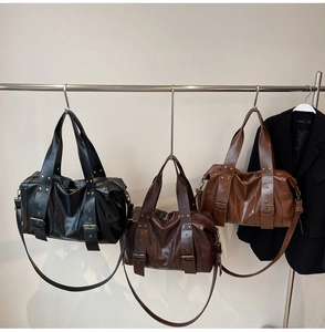 Detail of vintage large tote bags with rivets and adjustable straps in three colors