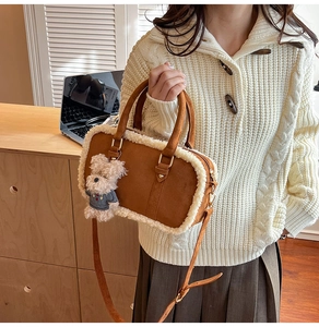Detail of brown suede bag with faux shearling trim and cute teddy bear charm