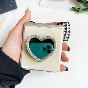 Detail of Galaxy Z Flip case featuring a heart-shaped rhinestone mirror and plaid strap