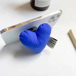 Close-up of blue puffer heart phone grip with fabric texture and side label