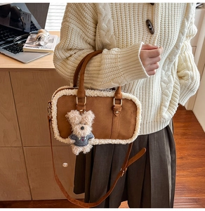 Brown suede shoulder bag with white faux fur trim and cute bear charm in cozy room