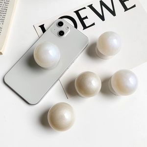 Macro view of glossy pearl-like phone grip socket attached to a smartphone back