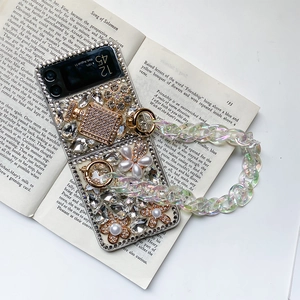 Close-up of luxury Samsung Z Flip case with rhinestones, pearls, and iridescent chain strap