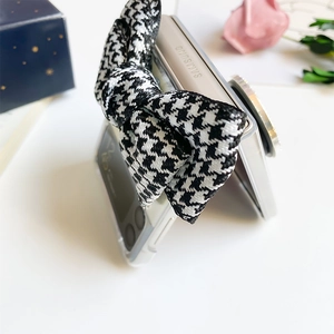 Macro detail of houndstooth bow ornament on a clear case for Samsung Z Flip series