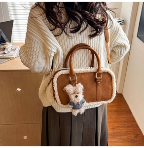 Close-up of brown suede handbag with white faux fur trim and cute teddy bear pendant
