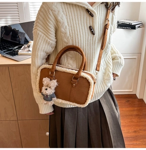 Detail of brown faux leather crossbody bag with faux shearling trim and cute bear charm