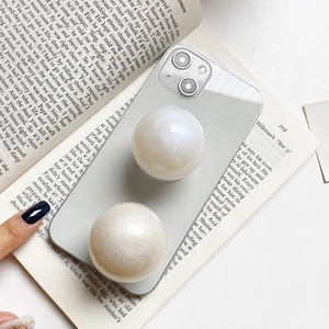 Macro detail of dual pearl-texture spherical popsocket stands on clear phone case