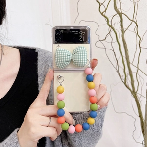 Detail of Galaxy Z Flip case with green plaid bow and colorful beaded wrist strap