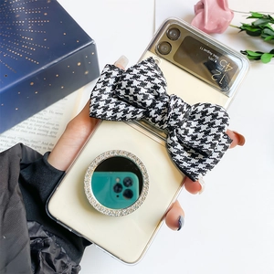 Detail of Galaxy Z Flip case featuring a houndstooth bow and rhinestone makeup mirror