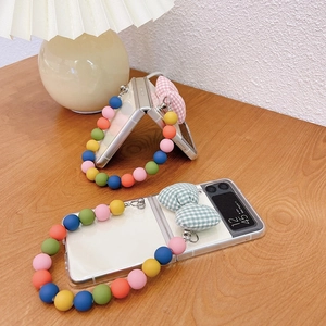 Close-up of clear phone case with colorful beaded bracelet and plaid bow for Z Flip series