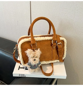 Detail of brown faux suede bag with white faux fur trim and cute teddy bear charm