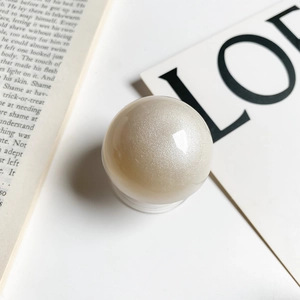 Detailed view of spherical pearl white phone grip with shimmering pearlescent finish